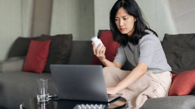 Hasta Asyalı kadın bilgisayarında tele-sağlık konferans uygulaması olan bir video konferansı düzenliyor..