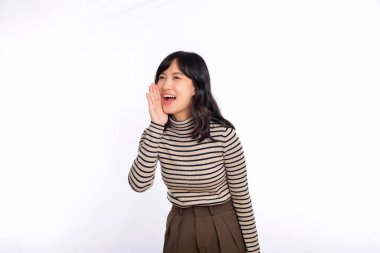 Happy asian woman, professional entrepreneur standing in casual clothing, open mouths raising hands shout announcement, white background