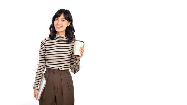 漂亮的年轻亚洲女人穿着毛衣 手持笔记本电脑和咖啡杯 笑容满面 与白色背景隔离 — 图库照片