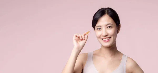 若い肖像画アジアの女性ビタミン栄養薬で幸せな笑顔の顔 ピンクの背景に隔離されたかなりかわいい女の子の女性の人健康カプセルサプリメントスキンケアを保持 薬の概念 — ストック写真