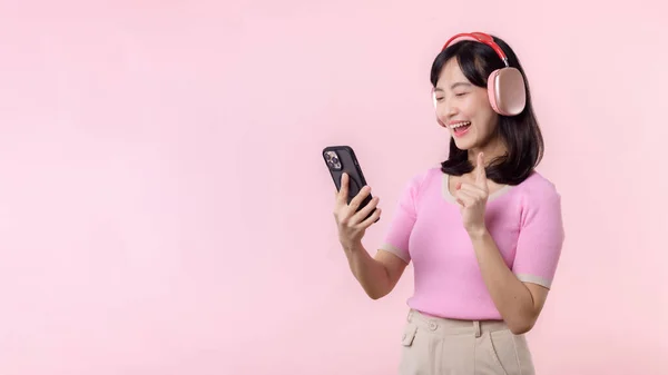 성격의 여성은 스마트폰 애플리케이션을 핑크에 대항하여 음성을 즐긴다 헤드폰을 여성분 — 스톡 사진