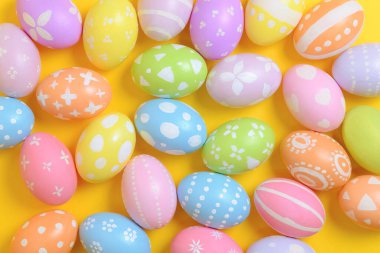 Mutlu Paskalya bayramı kutlamaları. Sarı arka planda renkli yumurta süsleme grubu. Mevsimsel din geleneği tasarımı. Üst görünüm, kopyalama alanı, düz uzanma.