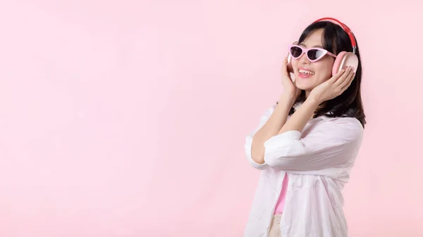 유행하는 선글라스를 착용하고 아시아인 모델은 헤드폰 오디오로 음악을 스튜디오 배경에서 — 스톡 사진