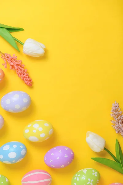 复活节快乐贺卡的概念 五彩缤纷的复活节彩蛋和黄色背景的春花 顶视图 复制空间 — 图库照片
