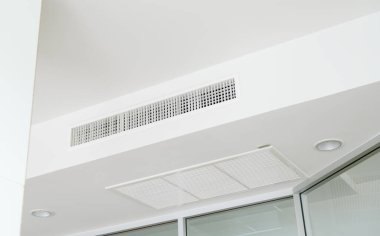 Tavana monte edilmiş kaset tipi klima ve beyaz tavanda modern lamba ışığı. Ofis ya da ev havalandırması