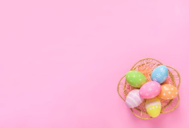 Mutlu Paskalya bayramı tebrik kartı konsepti. Renkli Paskalya yumurtası pastel pembe arka plan. Üst görünüm, düz görünüm, kopyalama alanı.
