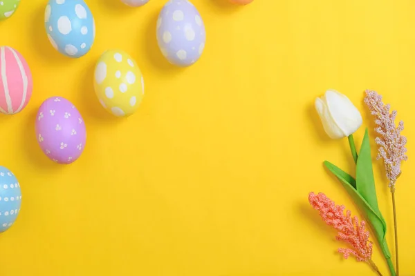 复活节快乐贺卡的概念 五彩缤纷的复活节彩蛋和黄色背景的春花 顶视图 复制空间 — 图库照片
