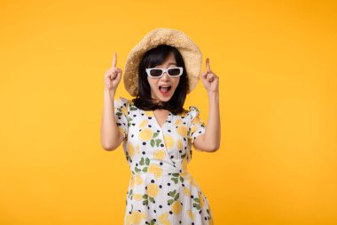 Genç, neşeli Asyalı kadın mutlu bir gülümseme ilkbahar kadın tarzı moda ve sarı arka planda izole edilmiş güneş gözlükleri. Çekici, güzel, manken kız yaz mevsiminde duygu pozu veriyor..