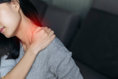 Asian woman has shoulder pain. Female holding painful shoulder with another hand. People with body-muscles problem