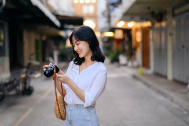 Asian woman traveler using camera. Asia summer tourism concept