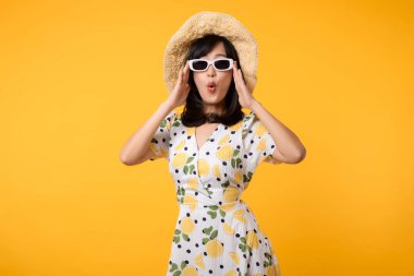 Genç, neşeli Asyalı kadın mutlu bir gülümseme ilkbahar kadın tarzı moda ve sarı arka planda izole edilmiş güneş gözlükleri. Çekici, güzel, manken kız yaz mevsiminde duygu pozu veriyor..