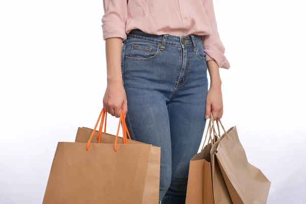 白い背景に隔離されたショッピングペーパーバッグを保持カジュアル服を持つ女性の手のクローズアップ 生態系のショッピングパッケージコンセプト — ストック写真