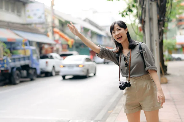 Χαμογελώντας Νεαρή Ασιάτισσα Ταξιδιώτισσα Κάνοντας Ωτοστόπ Ένα Δρόμο Στην Πόλη — Φωτογραφία Αρχείου
