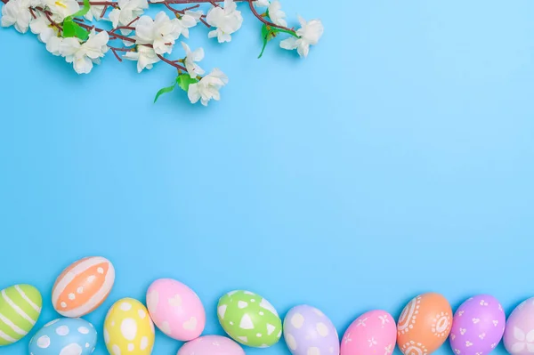 复活节快乐贺卡的概念 五彩缤纷的复活节彩蛋和蓝色背景的春花 顶视图 复制空间 — 图库照片