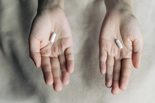 Kobiece Ręce Trzymają Oferują Dwie Kapsułki Lekami Wyboru Białe Różowe — Zdjęcie stockowe