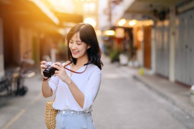 Asian woman traveler using camera. Asia summer tourism concept