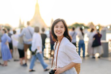 Güzel Asyalı kadının portresi Wat Arun 'da gün batımı manzarasında gülümsüyor, Bangkok, Tayland.