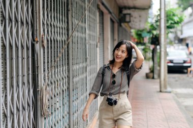 Young Asian woman backpack traveler enjoying street cultural local place and smile.