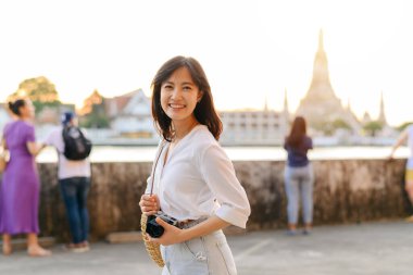 Güzel Asyalı kadının portresi Wat Arun 'da gün batımı manzarasında gülümsüyor, Bangkok, Tayland.