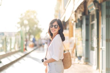 Portrait of young beautiful woman with camera explore street in Bangkok, Thailand