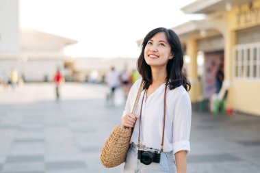 Portrait of young beautiful woman with camera explore street in Bangkok, Thailand