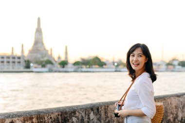 Güzel Asyalı kadının portresi Wat Arun 'da gün batımı manzarasında gülümsüyor, Bangkok, Tayland.