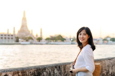 Portrait beautiful asian woman smiling while travel at Wat Arun sunset view point, Bangkok, Thailand.