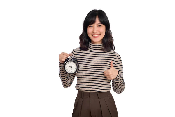 笑顔陽気な魅力的な若いブルネットアジアの女性を身に着けているセーターシャツ立っている時計を見せます親指アップカメラ上の白い背景 スタジオの肖像画 — ストック写真