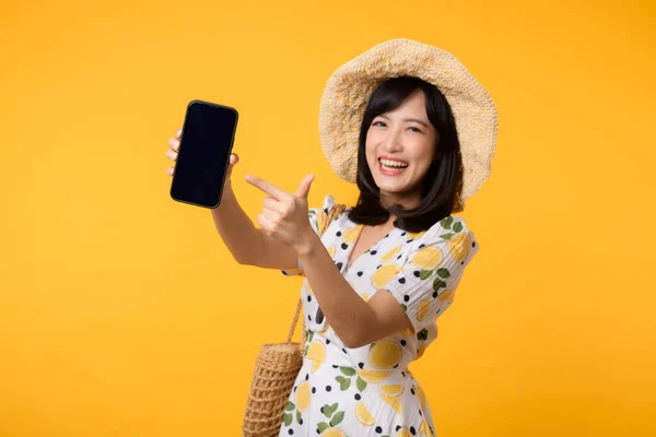 stock image Portrait happy asian young woman with springtime dress fashion showing blank mobile application display screen for advertisement isolated on yellow background. Smartphone app technology concept.