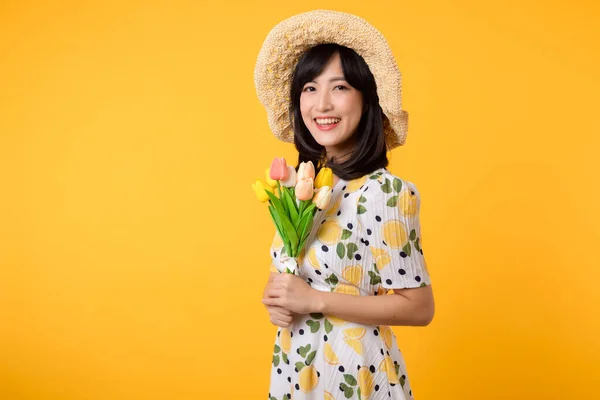 工作室的肖像漂亮年轻的亚洲女人快乐的笑着穿着春天时尚服饰头戴郁金香花束的帽子在黄色的工作室背景下 个人假日概念 — 图库照片