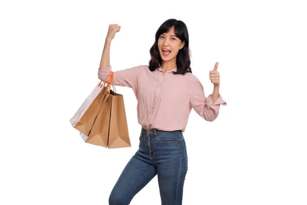 若いです幸せなアジアの女性とともにカジュアルシャツとデニムジーンズ保持ショッピングバッグ上の白い背景 — ストック写真