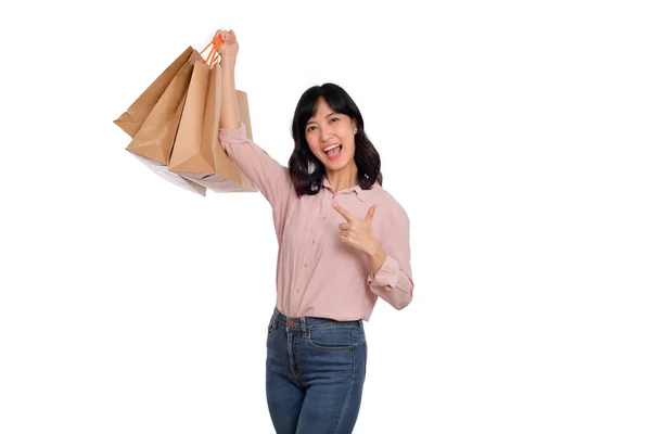 若いです幸せなアジアの女性とともにカジュアルシャツとデニムジーンズ保持ショッピングバッグ上の白い背景 — ストック写真