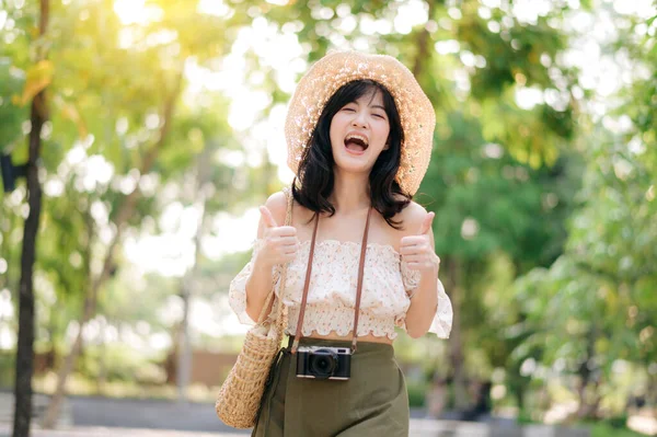帽子とバスケットを織る若いアジアの女性旅行者の肖像画や緑の公園の自然背景にカメラ 旅のライフスタイル 世界旅行探検家またはアジアの夏の観光コンセプト — ストック写真