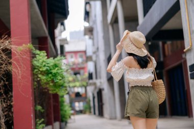 Kameralı mutlu Asyalı genç kadın hafta sonu şehir gezisine çıkıyor. Genç hippi bayan turist yaz Bangkok 'u geziyor. Asya yaz turizmi kavramı.
