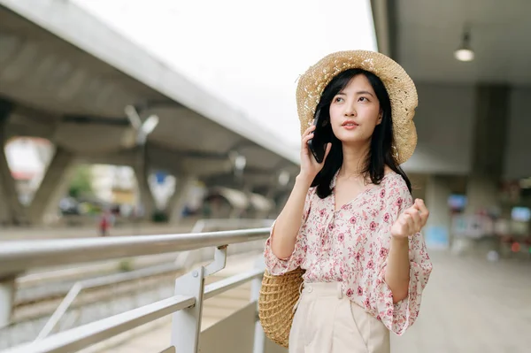 Mladá Asijská Žena Cestovatel Tkalcovský Koš Pomocí Mobilního Telefonu Vedle — Stock fotografie