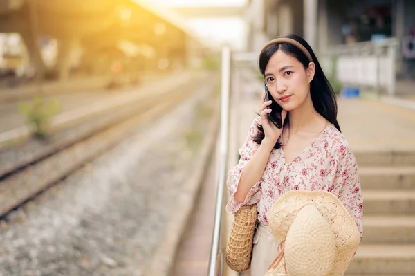 在曼谷火车站旁边 年轻的亚洲妇女带着编织帽 用手机旅行 旅行生活方式 世界旅游探险家或亚洲夏季旅游概念 — 图库照片