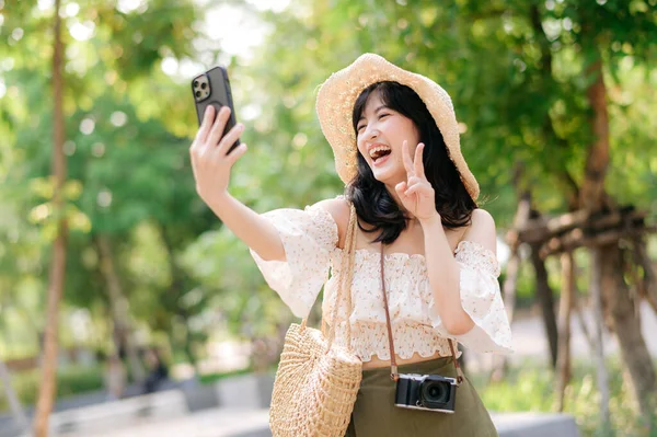 배경에는 천으로 바구니 카메라를 가지고 여행하는 아시아 여인의 모습이 그려져 — 스톡 사진