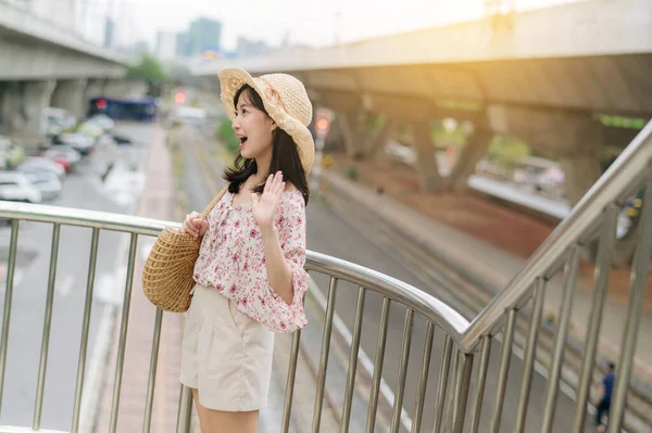 亚洲年轻女子带着编织篮子快乐地笑着站在有铁路背景的天桥上 旅行生活方式 世界旅游探险家或亚洲夏季旅游概念 — 图库照片