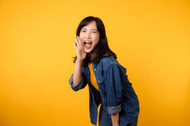 Sarı tişörtlü, ağzı açık, el kaldıran, sarı arka planda izole edilmiş çığlık atan Asyalı genç kadın. Yaşam tarzı portre konsepti.