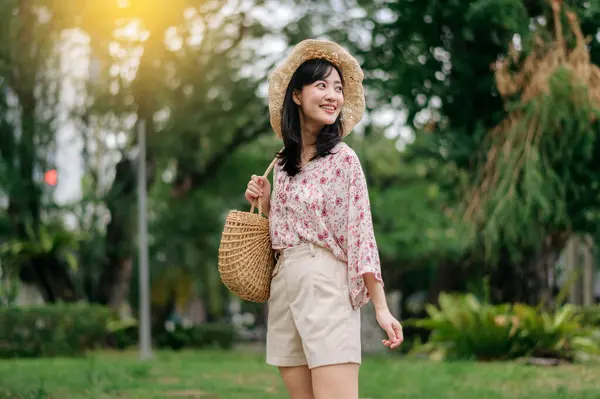 緑の公園の自然を背景に帽子とバスケット幸せな笑顔を織って若いアジアの女性旅行者の肖像画 旅のライフスタイル 世界旅行探検家またはアジアの夏の観光コンセプト — ストック写真