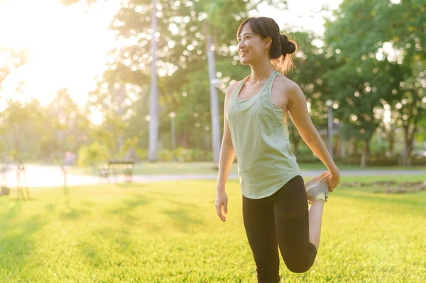 女慢跑者 让亚洲年轻女子穿着绿色运动服 在公园里伸展肌肉 然后跑到户外享受健康的生活 健身跑步的女孩在公共公园 健康是概念 — 图库照片