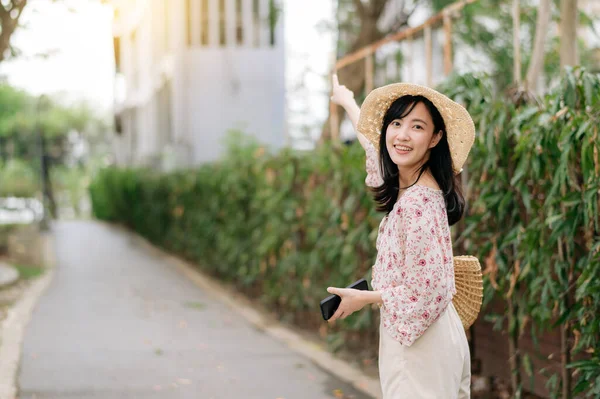 年轻的亚洲女性旅行者的画像 戴着编织的帽子 带着篮子 在绿色的公园自然背景下开开心心地微笑 旅行生活方式 世界旅游探险家或亚洲夏季旅游概念 — 图库照片