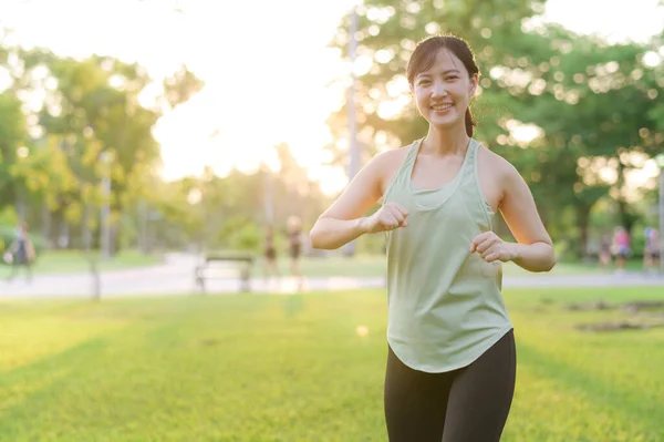 女慢跑者 让亚洲年轻女子穿着绿色运动服 在公园里伸展肌肉 然后跑到户外享受健康的生活 健身跑步的女孩在公共公园 健康是概念 — 图库照片