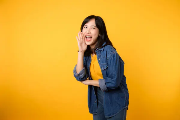黄色のTシャツを着たアジア系の若い女性が口を開けたままデニムシャツを着ている ライフスタイルポートレートのコンセプト — ストック写真