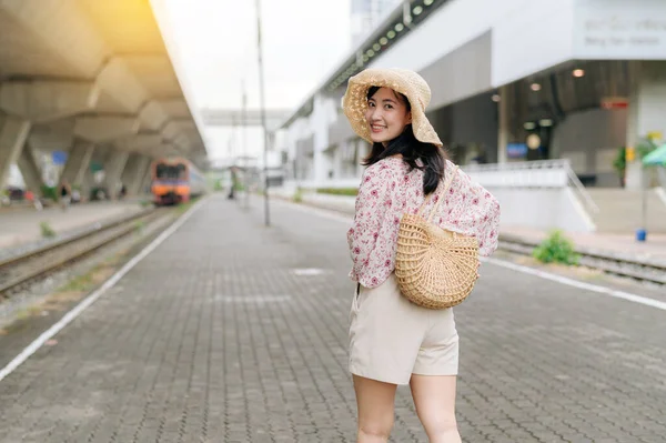 亚洲的年轻女性旅行者带着编织的篮子回头看 开心地笑着看着火车旁边的摄像机 旅行生活方式 世界旅游探险家或亚洲夏季旅游概念 — 图库照片