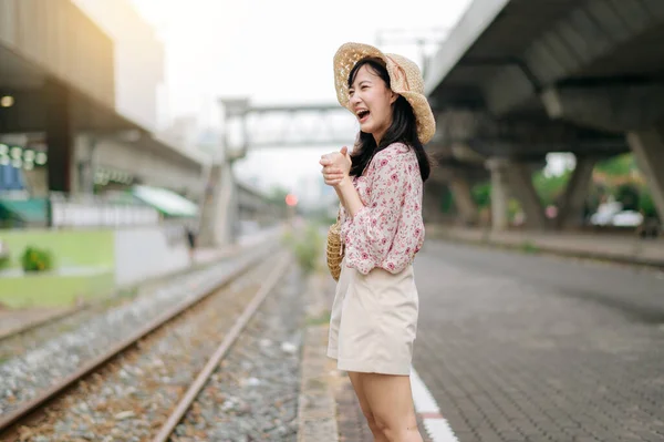 Tren Yolunun Yanındaki Kameraya Gülümseyen Sepetli Asyalı Genç Kadın Gezgin — Stok fotoğraf