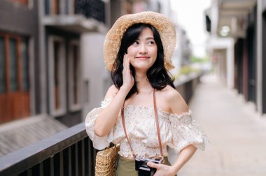 Kameralı mutlu Asyalı genç kadın hafta sonu şehir gezisine çıkıyor. Genç hippi bayan turist yaz Bangkok 'u geziyor. Asya yaz turizmi kavramı.