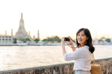 Güzel Asyalı kadının portresi Wat Arun 'da gün batımı manzarasında gülümsüyor, Bangkok, Tayland.