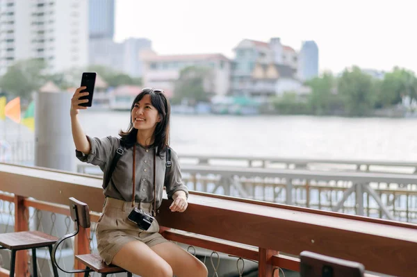 在曼谷Chao Phraya河的快艇码头 年轻的亚洲女子背包客使用手机 旅客在侧街办理登机手续 — 图库照片