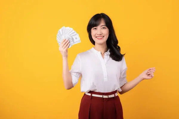 年轻美丽的亚裔女企业家的画像 穿着白衬衫 头戴红色的植物 背景为黄色 背景为金钱隔离 面带微笑 资金在线支付概念 — 图库照片